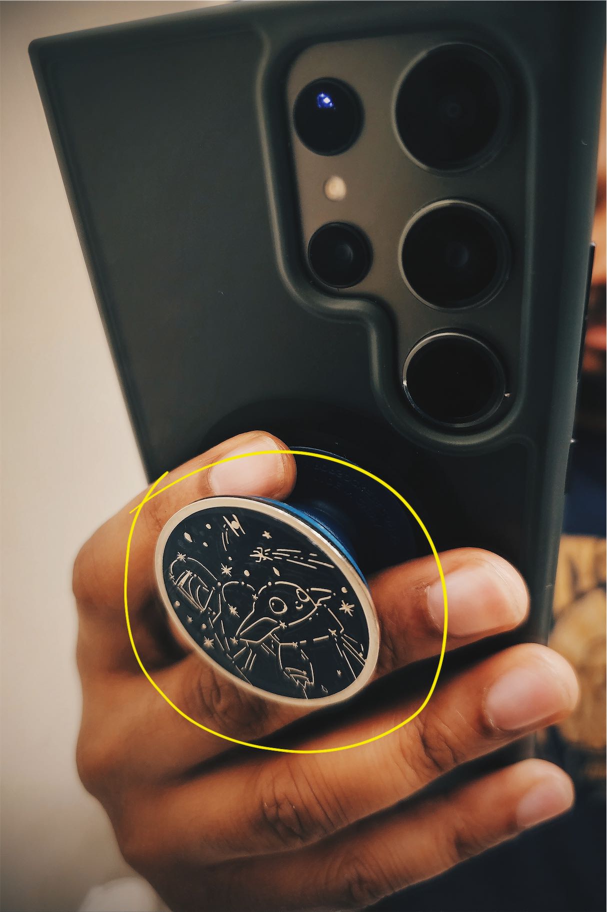 Close up of my phone with an annotated yellow circle around the attached Pop Socket.